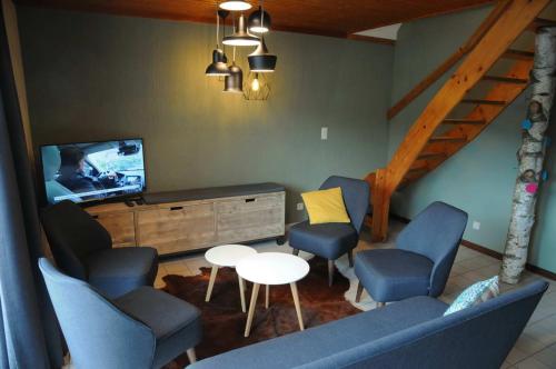 a living room with chairs and a tv and a table at Maison du Lac 4 in Vielsalm