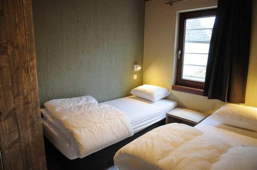 a room with two beds and a window at Maison du Lac 4 in Vielsalm