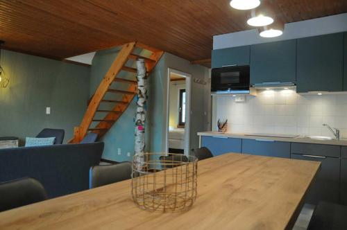 a kitchen with a wooden table and a spiral staircase at Maison du Lac 4 in Vielsalm