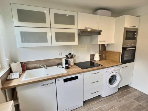 une cuisine avec un évier et une machine à laver dans l'établissement Charmante maison de ville, à Montreuil