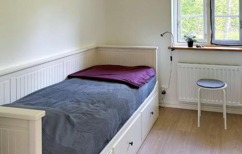 a bed in a room with a chair and a window at Gorgeous Home In Brösarp With Wifi in Brösarp
