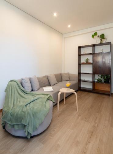a living room with a couch and a table at Jardim do Morro Apartment By Porto Stories in Vila Nova de Gaia