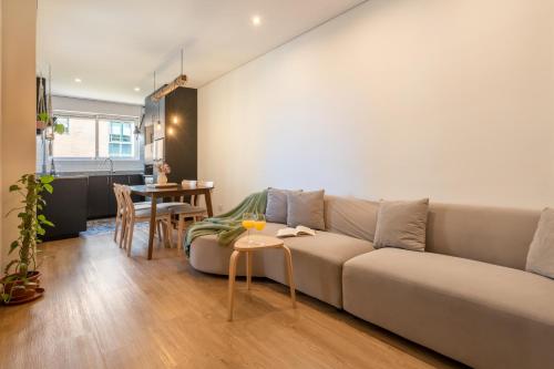 a living room with a couch and a table at Jardim do Morro Apartment By Porto Stories in Vila Nova de Gaia