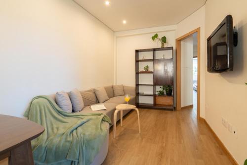 a living room with a couch and a tv at Jardim do Morro Apartment By Porto Stories in Vila Nova de Gaia