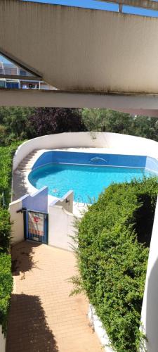 deux photos d'une piscine dans un bâtiment dans l'établissement Joli studio avec piscine à 200m de la plage parking privé, à La Grande Motte