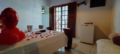 a room with a table with red rose petals on it at Pousada Aconchego in Pirenópolis