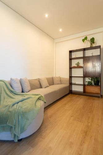 a living room with a couch and a book shelf at Jardim do Morro Apartment By Porto Stories in Vila Nova de Gaia