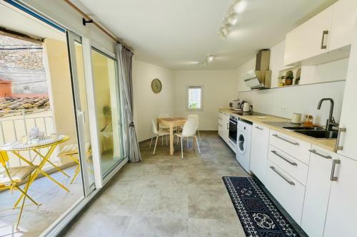 une cuisine avec des placards blancs, une table et une table dans l'établissement 