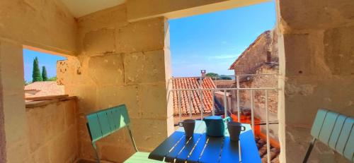 une table et des chaises sur un balcon avec vue dans l'établissement Les Sarments charme de l'Ancien renové et au calme, à Mus