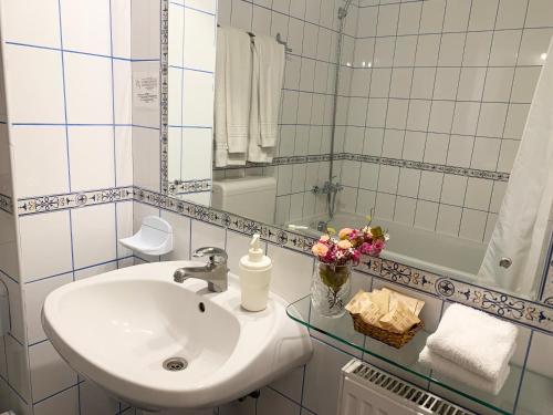 a white bathroom with a sink and a mirror at Pension Casa Olga in Paraul Rece