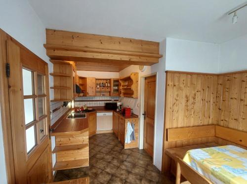 a large kitchen with wooden cabinets and a window at Alpenblick FeWo Hauser in Reisach