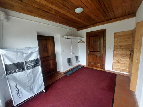 a room with two wooden doors and a red carpet at Alpenblick FeWo Hauser in Reisach
