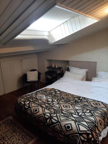 une chambre avec un lit et une lucarne dans l'établissement Maison de charme, à La Rochelle
