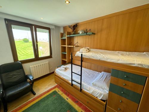 a bedroom with a bunk bed and a chair at Playa de los Locos con Garaje Recién Reformado!! in Suances
