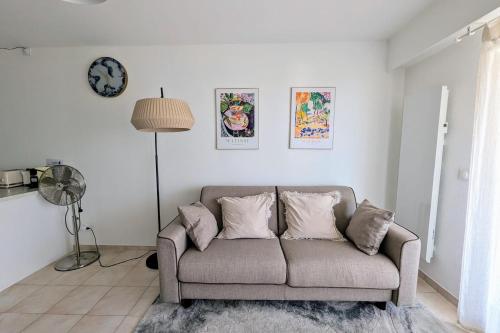 un salon avec un canapé et une horloge au mur dans l'établissement JUAN LES PINS - TOWN CENTER - 4 people, à Antibes