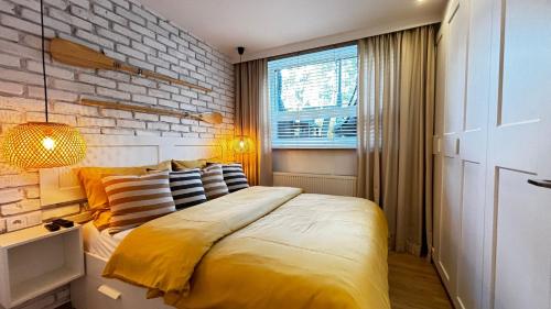 sypialnia z dużym łóżkiem i ceglaną ścianą w obiekcie Komfortowy Apartament Rodzinny Forest&Sea lllA w Świnoujściu