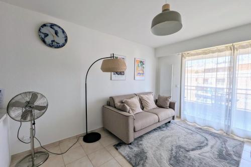 un salon avec un canapé et une horloge au mur dans l'établissement JUAN LES PINS - TOWN CENTER - 4 people, à Antibes