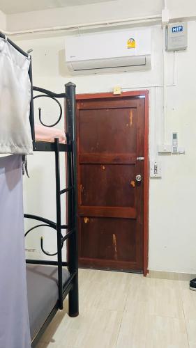 a room with a bunk bed and a wooden door at The Dreamcatcher Hostel Nathon SamuiSunset in Nathon