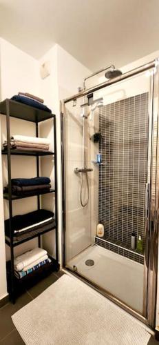 une douche avec une porte vitrée dans une salle de bain dans l'établissement All comfort -Parking&Fibre #WelcomeHome Gare Colombes, à Colombes