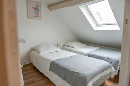 deux lits dans une petite pièce avec une fenêtre dans l'établissement Bleu Bonheur, appartement cosy au coeur de la Baie, à Saint-Valery-sur-Somme