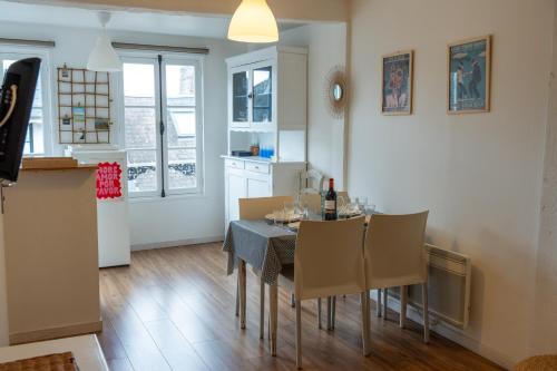 une cuisine et une salle à manger avec une table et des chaises dans l'établissement Bleu Bonheur, appartement cosy au coeur de la Baie, à Saint-Valery-sur-Somme