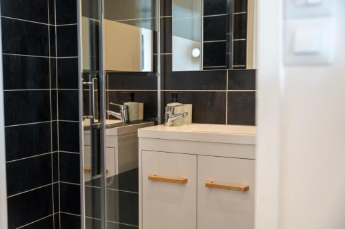une salle de bain avec un lavabo et un miroir dans l'établissement Bleu Bonheur, appartement cosy au coeur de la Baie, à Saint-Valery-sur-Somme