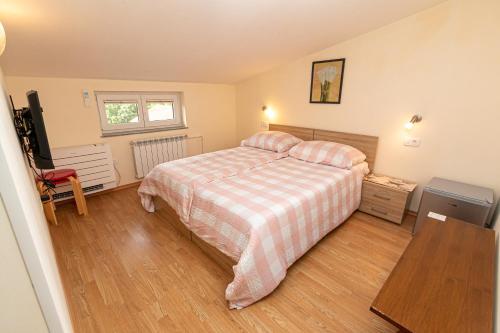 a bedroom with a bed with a checkered blanket at Penzion Na Hribu in Slap