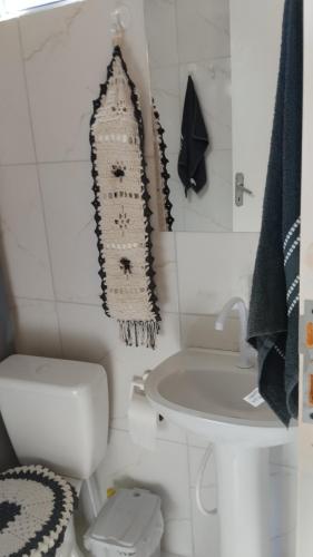 a bathroom with a toilet and a rug hanging on the wall at Sítio são longuinho in Extrema