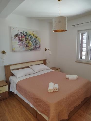 a bedroom with a bed with two towels on it at Apartments Tonka in Bol