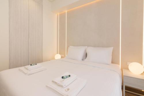 a white bed with two white towels on it at Socrates Fully Equipped Apartments with Unique Design in Athens