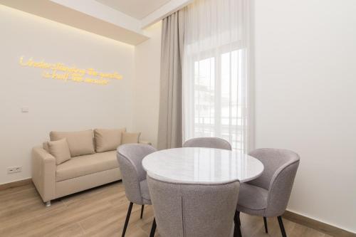 a dining room with a table and chairs and a couch at Socrates Fully Equipped Apartments with Unique Design in Athens