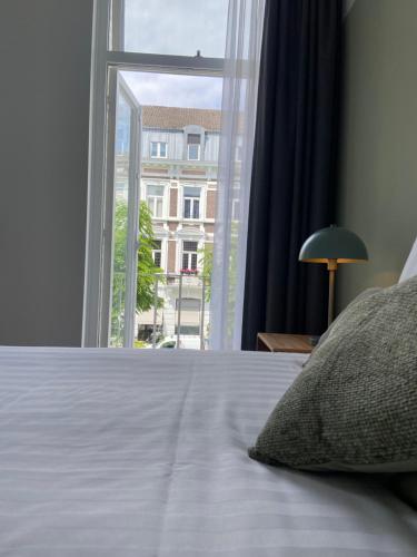 a bedroom with a bed and a large window at Alex Maastricht in Maastricht