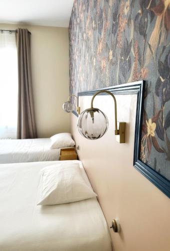 a hotel room with two beds and a mirror at Le Florus in Montrouge