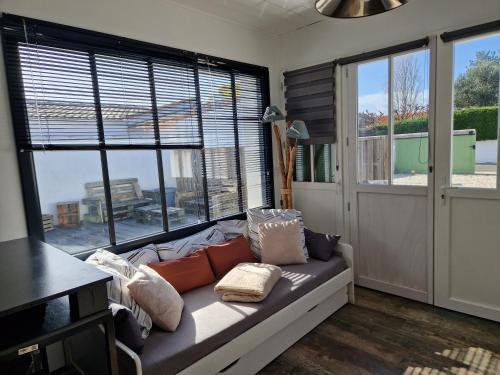 a living room with a couch and two large windows at le Paradis in La Noue