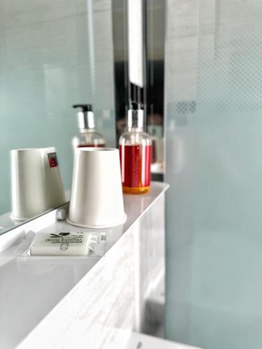 a bathroom counter with two lamps and a mirror at Le Florus in Montrouge