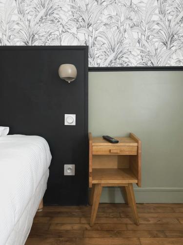 a bedroom with a bed and a nightstand with a table at Le Florus in Montrouge