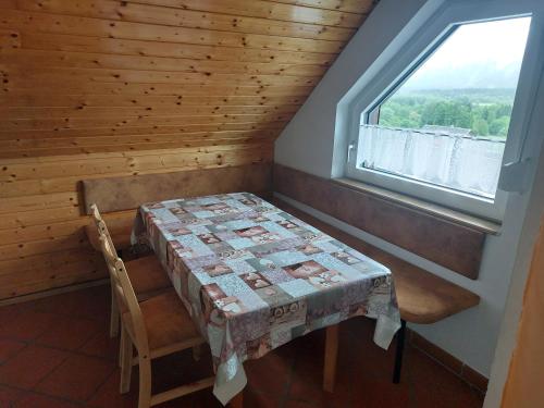 a table and chair in a room with a window at Alpenblick FeWo Hauser in Reisach