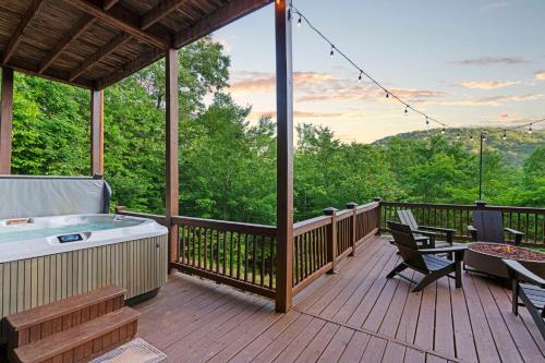 a deck with a hot tub and a table and chairs at The Remedy at Blue Ridge - mountain view cabin with hot tub and two fire pits in Cherry Log