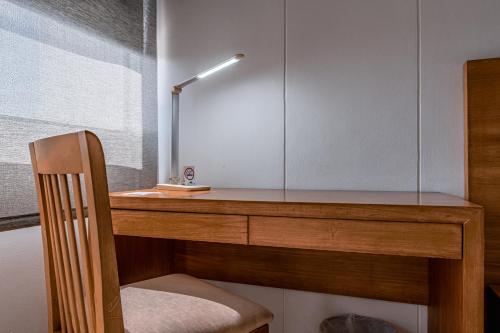 a wooden desk with a chair and a lamp on it at Hotel Barranquilla Plaza in Barranquilla