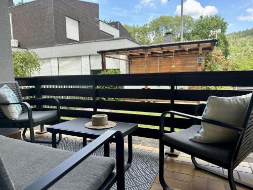 a patio with chairs and a table with a hat on it at Melanies Apartment in Burgsinn