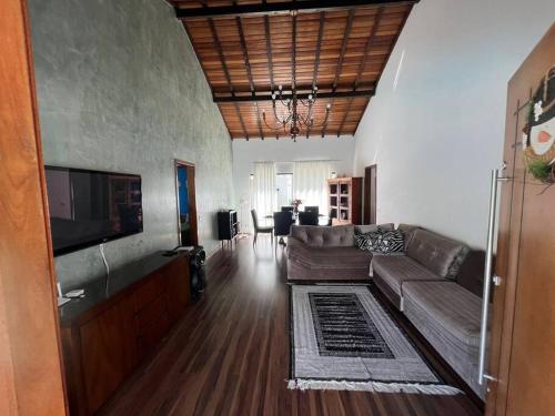 a living room with a couch and a flat screen tv at Casa de Campo Teresópolis in Teresópolis