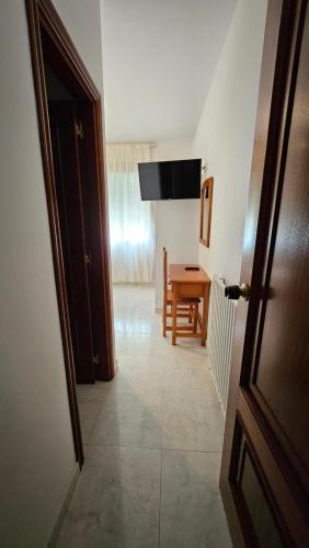 a hallway with a room with a table and a door at Hotel Nuevo Julios by Olda in Ribadumia