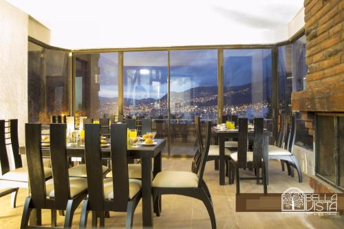 a dining room with tables and chairs and a large window at Hotel Bellavista Quito in Quito