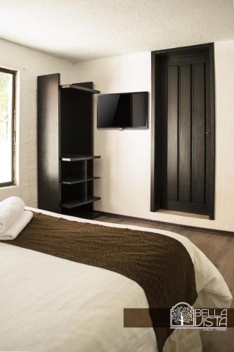 a bedroom with a bed with a tv and a bed at Hotel Bellavista Quito in Quito