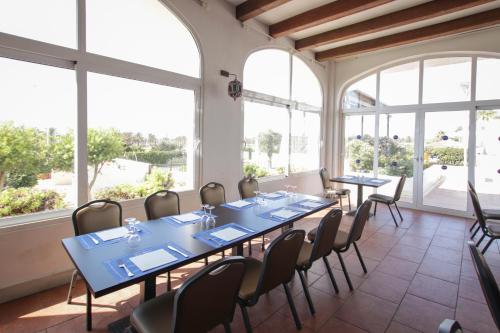 a conference room with tables and chairs and windows at Ohtels Cabogata in Retamar