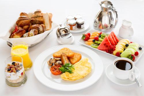 a table topped with plates of breakfast foods and coffee at Crowne Plaza College Park - Washington DC by IHG in Greenbelt