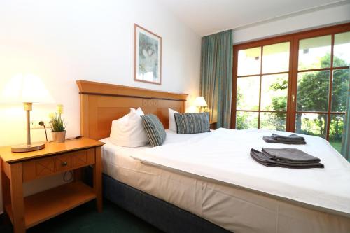 1 dormitorio con 1 cama blanca grande, escritorio y ventana en Oewern Diek App 02, en Wustrow
