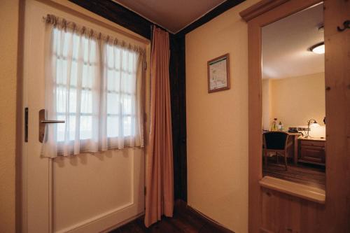a hallway with a door and a window and a desk at Hofgut Himmelreich in Kirchzarten