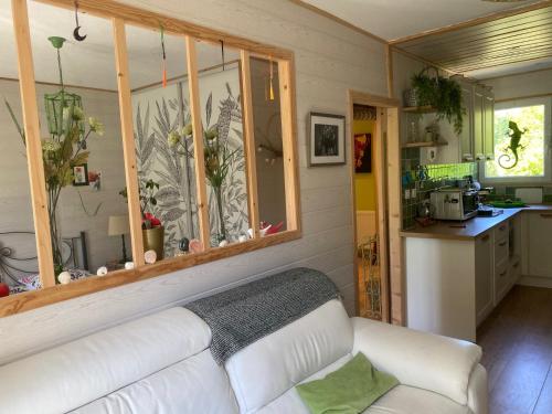 un salon avec un canapé blanc et une cuisine dans l'établissement Appartement SérénitE, à Putot-en-Auge