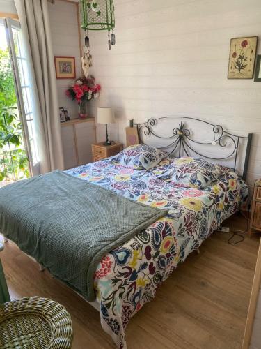 une chambre avec un lit avec une couette colorée dans l'établissement Appartement SérénitE, à Putot-en-Auge